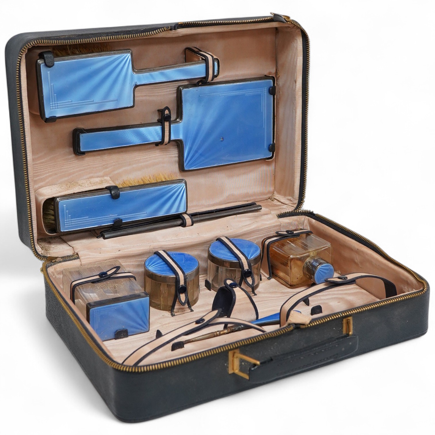 A George V/George VI Art Deco vanity case containing nine silver and blue guilloche enamel mounted items including a hand mirror, brushes, nail implement etc. Walker & Hall, 1936/37, incomplete.